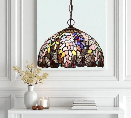 Stained glass pendant lamp with multicolor mosaic dome shade suspended from chain.