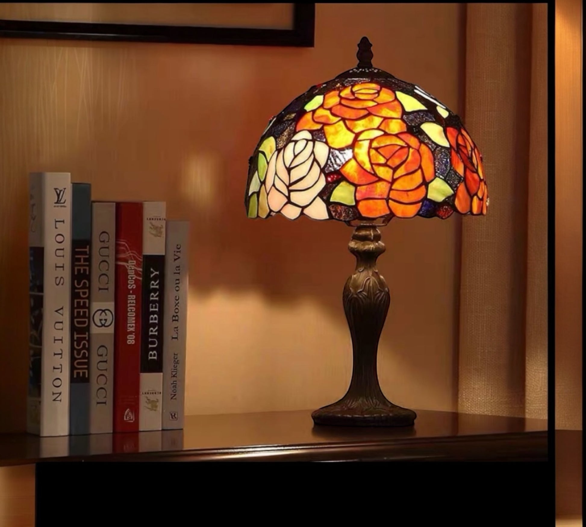 Stained glass lamp on a shelf with books in the background CDH Tiffany Table Lamp