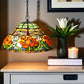 Stained glass lamp with floral design on a wooden surface with a candle and plant. NZ#1 Tiffany Lamp Seller