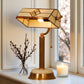 Decorative table lamp with stained glass shade on a surface near a window. CDH Tiffany Table Lamp