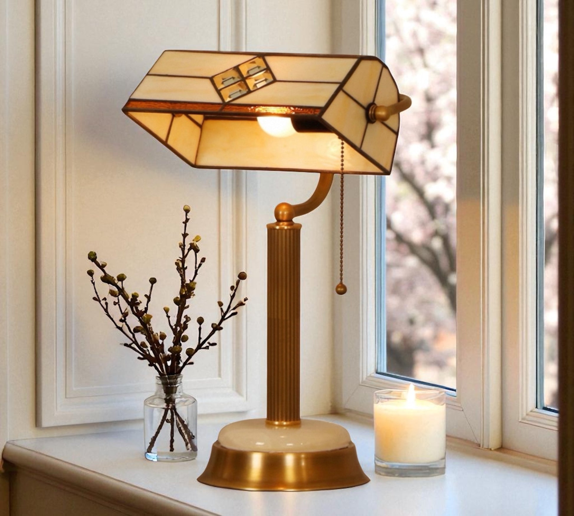 Decorative table lamp with stained glass shade on a surface near a window. CDH Tiffany Table Lamp