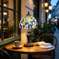 Tiffany table lamp with stained glass dome shade in blue, yellow, and white; bronze base