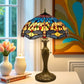 Tiffany-style table lamp with multicolor stained glass shade and bronze base, close side view