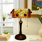 Stained-glass table lamp with scalloped yellow floral shade and dark metal base, pull cord