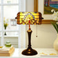 Stained glass table lamp with amber shade over dark bronze pedestal base