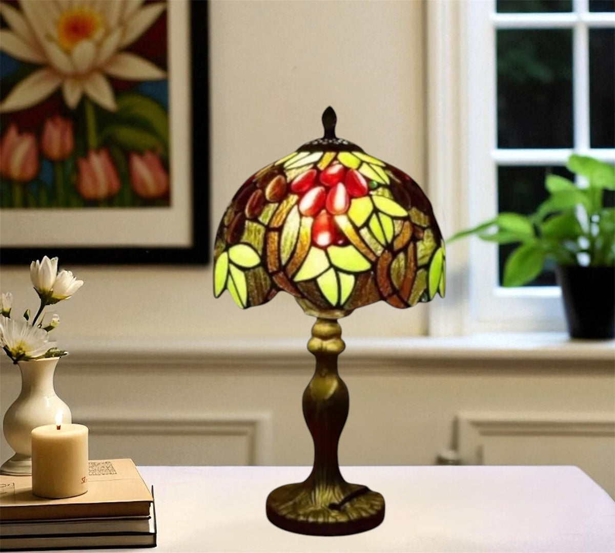 Tiffany-style stained glass table lamp with red flower shade and bronze base on a tabletop