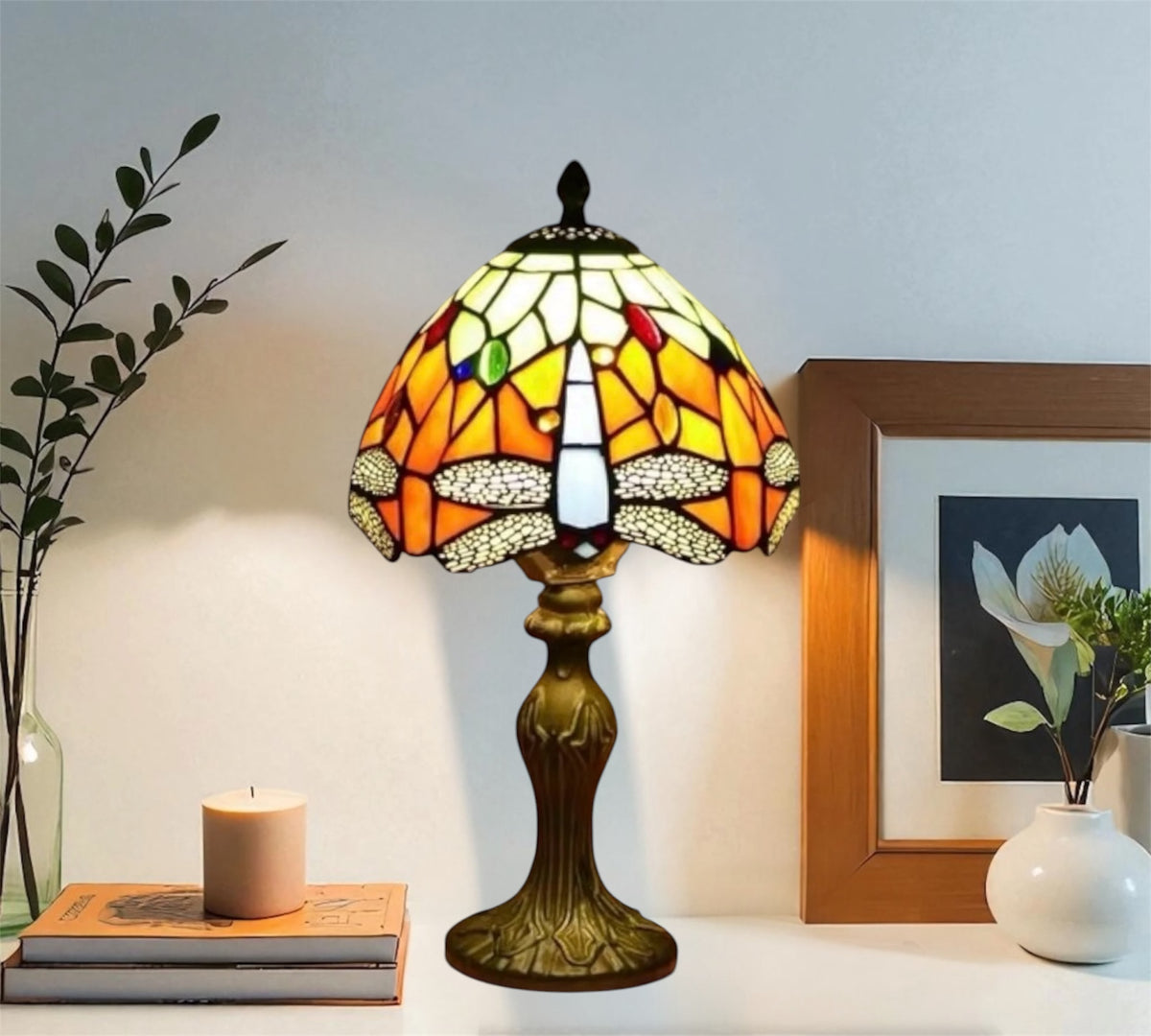 Tiffany-style stained glass table lamp with yellow-orange shade and dark metal base