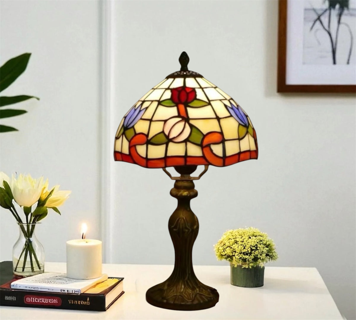 Tiffany-style stained glass table lamp with red floral shade and bronze base on side table.