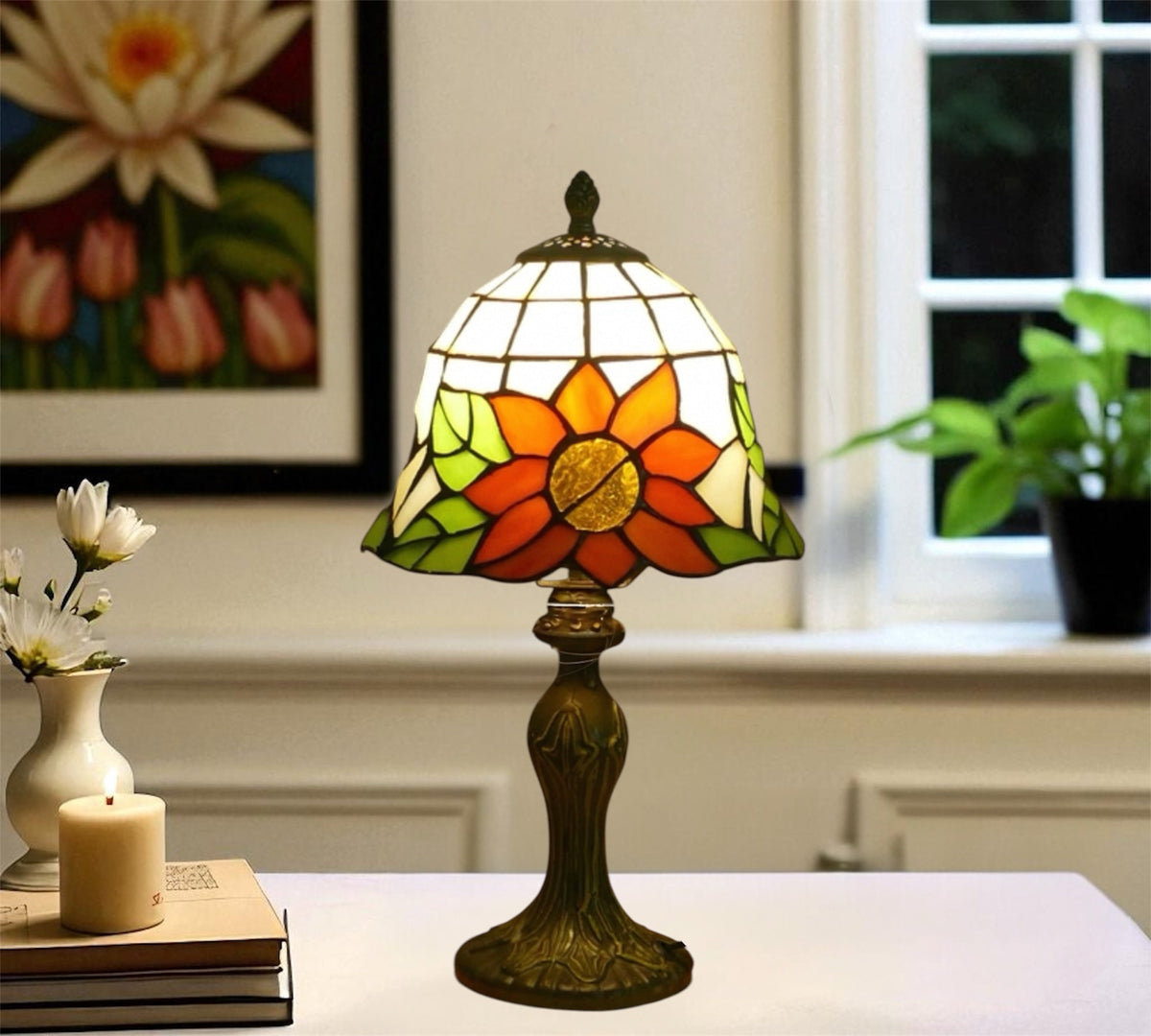 Tiffany-style stained glass table lamp with orange and green floral shade and dark metal base