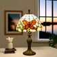 Tiffany table lamp with stained-glass orange butterfly shade on bronze base, finial top