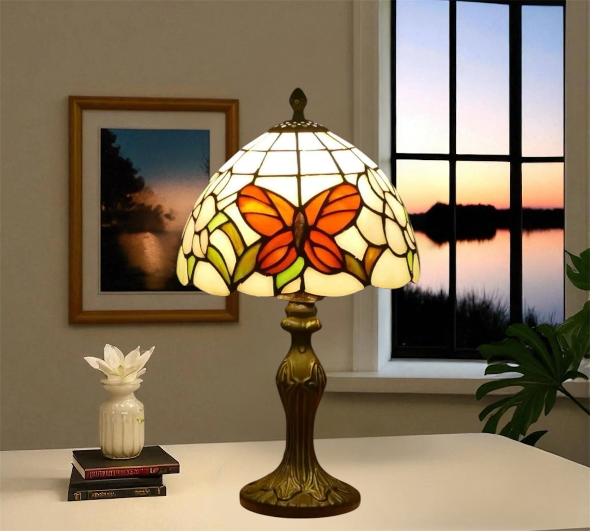 Tiffany table lamp with stained-glass orange butterfly shade on bronze base, finial top