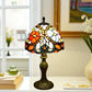 Tiffany table lamp with multicolor stained-glass shade and bronze base on tabletop