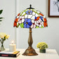 Multicolor stained glass table lamp with domed floral shade and ornate bronze base.