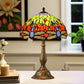 Tiffany-style table lamp with round stained-glass shade in green, orange and red and bronze base