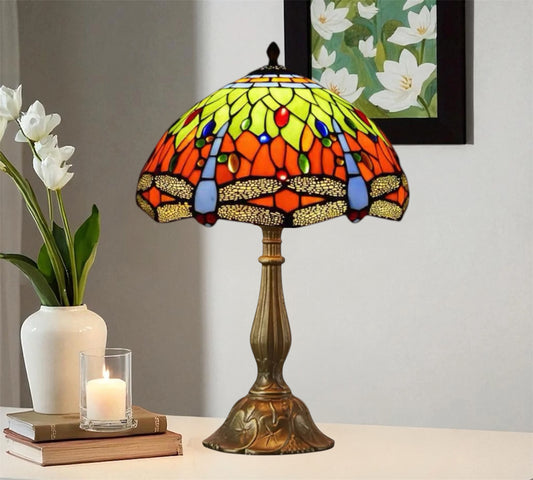 Stained glass table lamp featuring a green-yellow leaf shade with orange and red accents
