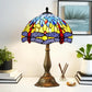 Tiffany table lamp featuring multicolor stained glass dome shade and bronze column base