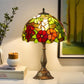 Bronze base stained glass table lamp with domed floral shade and top finial