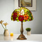Stained glass table lamp with domed multicolor floral shade and ornate bronze base