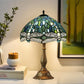 Green-blue mosaic stained glass table lamp with bronze stem and wide shade