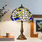 Tiffany-style stained-glass table lamp with blue-and-green shade and bronze base stand