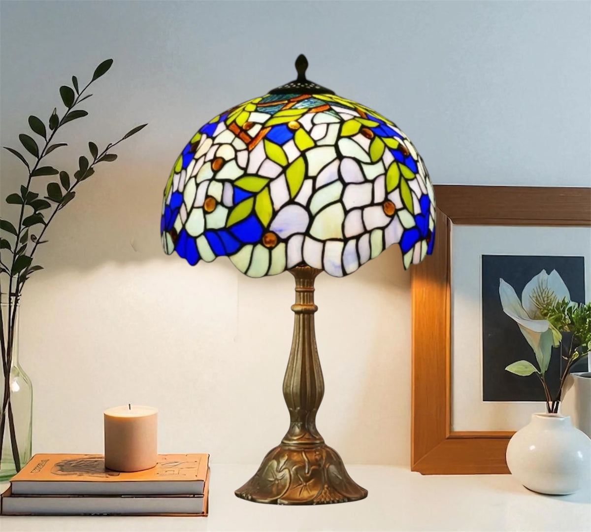 Tiffany-style stained-glass table lamp with blue-and-green shade and bronze base stand