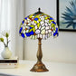 Tiffany-style table lamp with stained-glass shade in white, blue, and green and bronze base