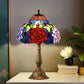 Tiffany-style stained glass table lamp with red rose shade and tall bronze metal stand.