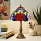 Stained glass Tiffany table lamp with red rose shade, blue trim, and bronze pedestal base.