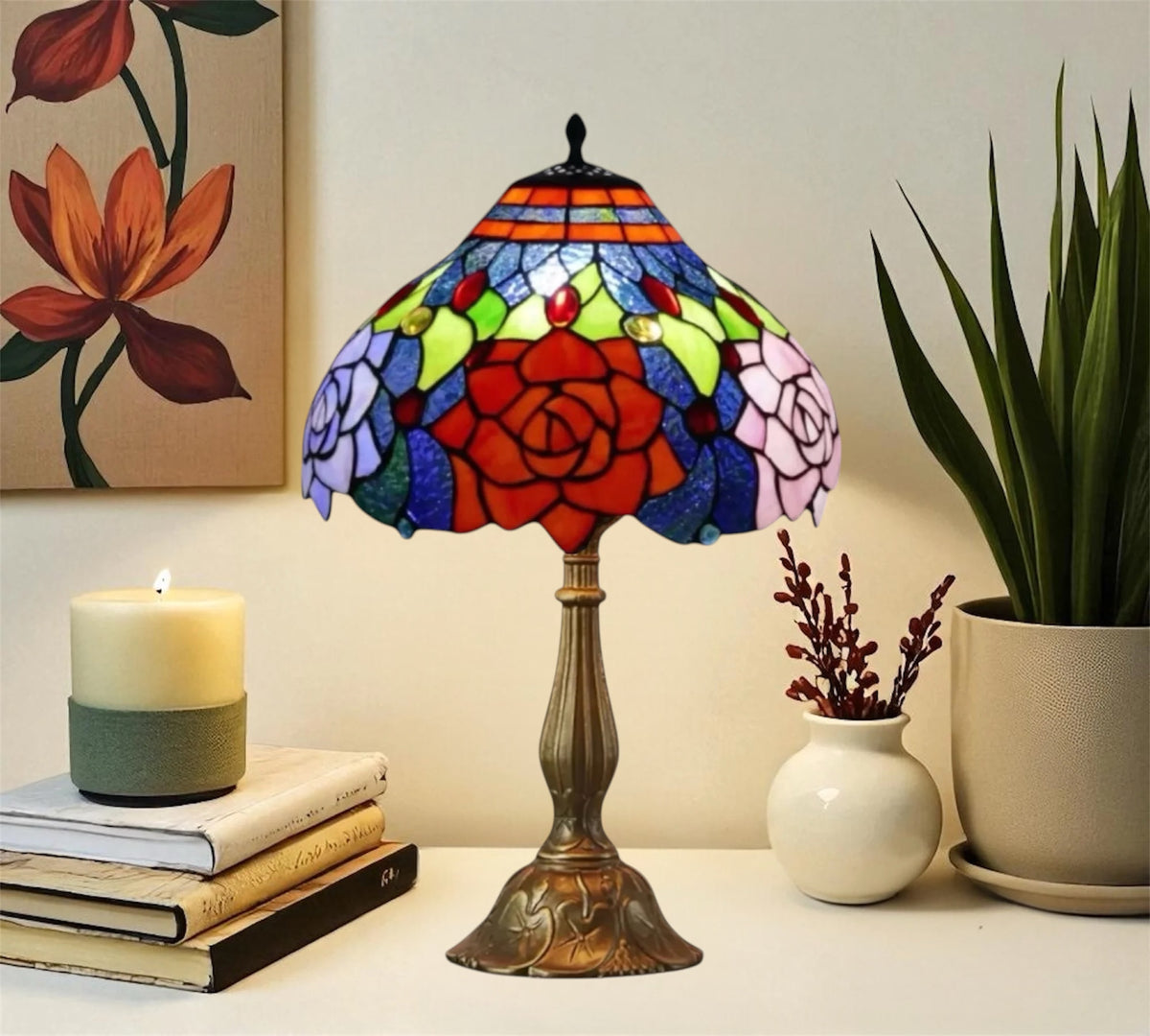 Stained glass Tiffany table lamp with red rose shade, blue trim, and bronze pedestal base.