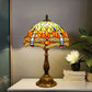 Tiffany table lamp on console: multicolor stained-glass shade with bronze base.
