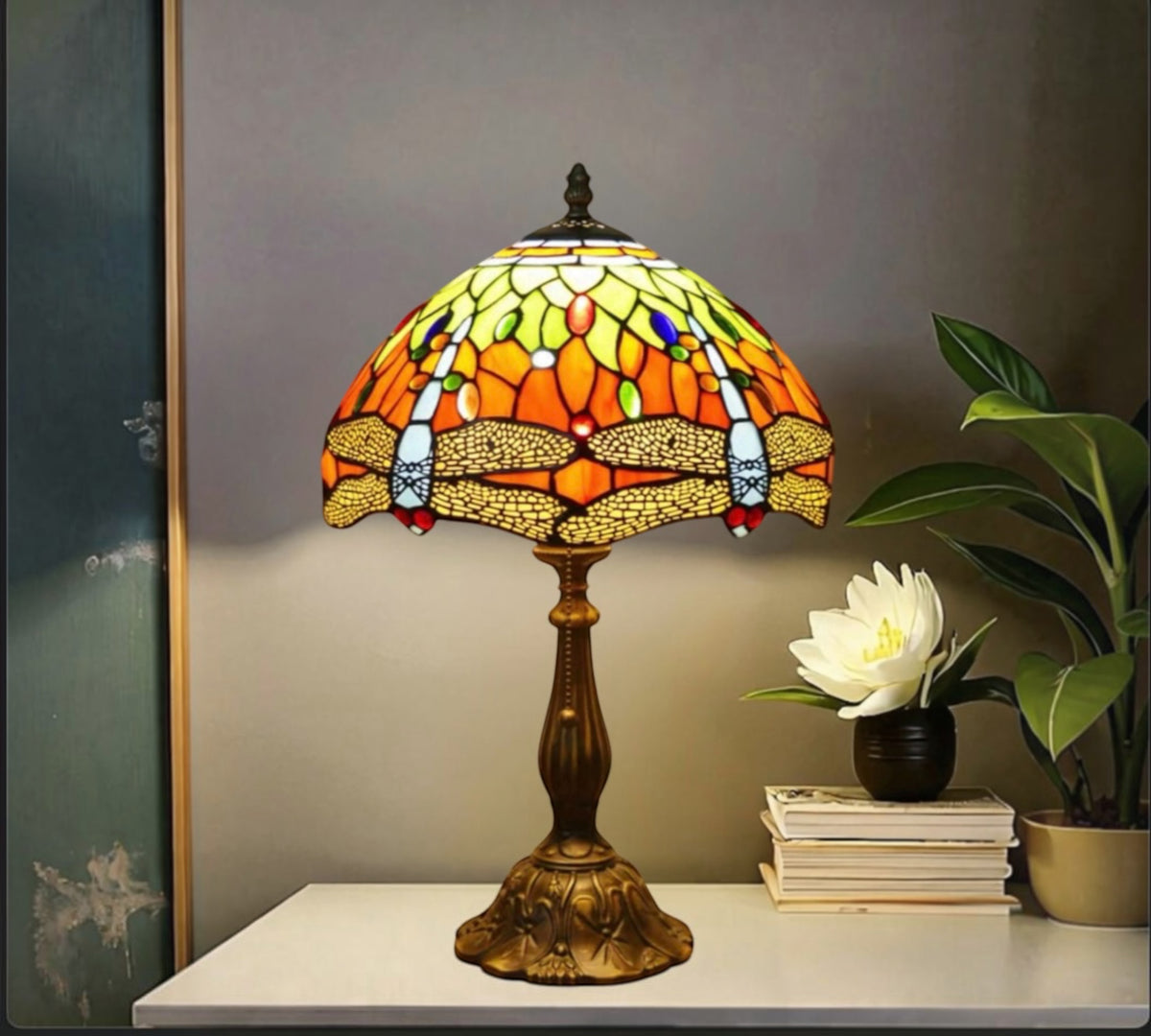 Tiffany table lamp on console: multicolor stained-glass shade with bronze base.