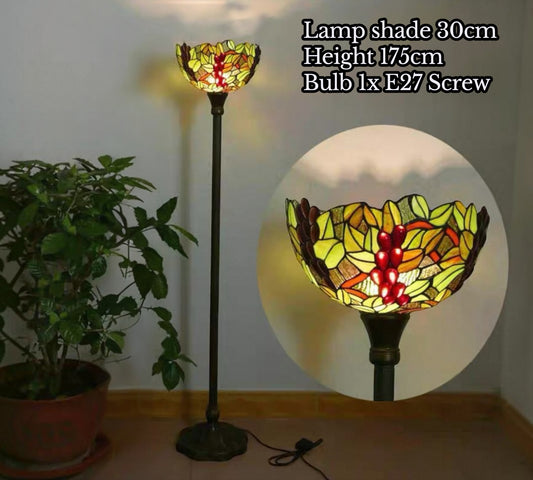 Stained glass torchiere floor lamp with green yellow red floral shade and slender dark base