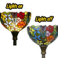 Pair of multicolor stained-glass lamp shades on dark bases, one illuminated and one off
