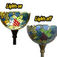 Stained glass lamp shade shows grape and leaf motifs on dark base; lights on/off comparison