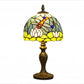 Stained glass table lamp with curved multicolor shade and ornate bronze metal base