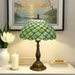 Tiffany-style table lamp with green stained-glass shade and bronze pedestal base