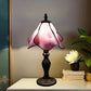 Tiffany style table lamp with pink stained-glass shade and dark metal base