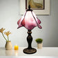 Pink stained-glass table lamp shade with petal edges and dark bronze base