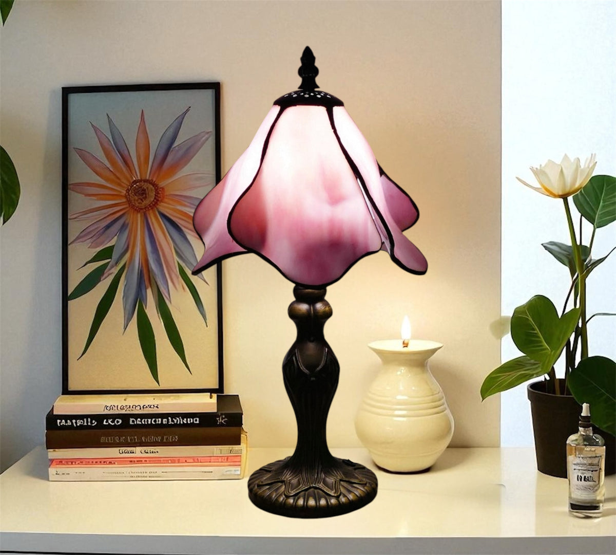 Tiffany table lamp with pink stained-glass shade, ornate dark base, bulb lit