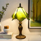 Tiffany table lamp with yellow-green stained glass shade and ornate metal base