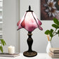 Pink stained-glass Tiffany table lamp with dark metal base and scalloped shade