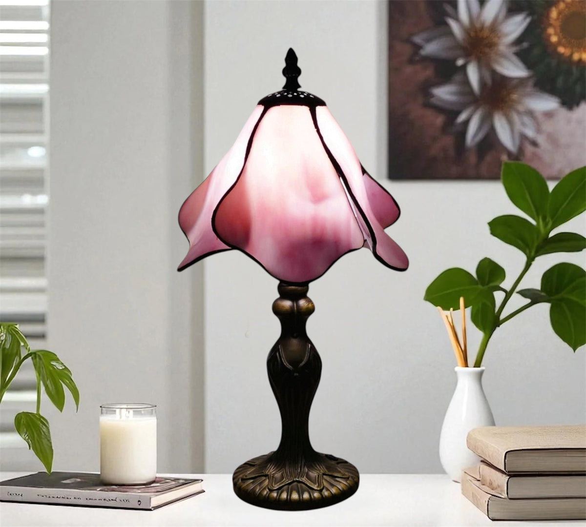 Pink stained-glass Tiffany table lamp with dark metal base and scalloped shade