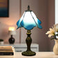 Blue stained glass table lamp with dark bronze base and dome shade