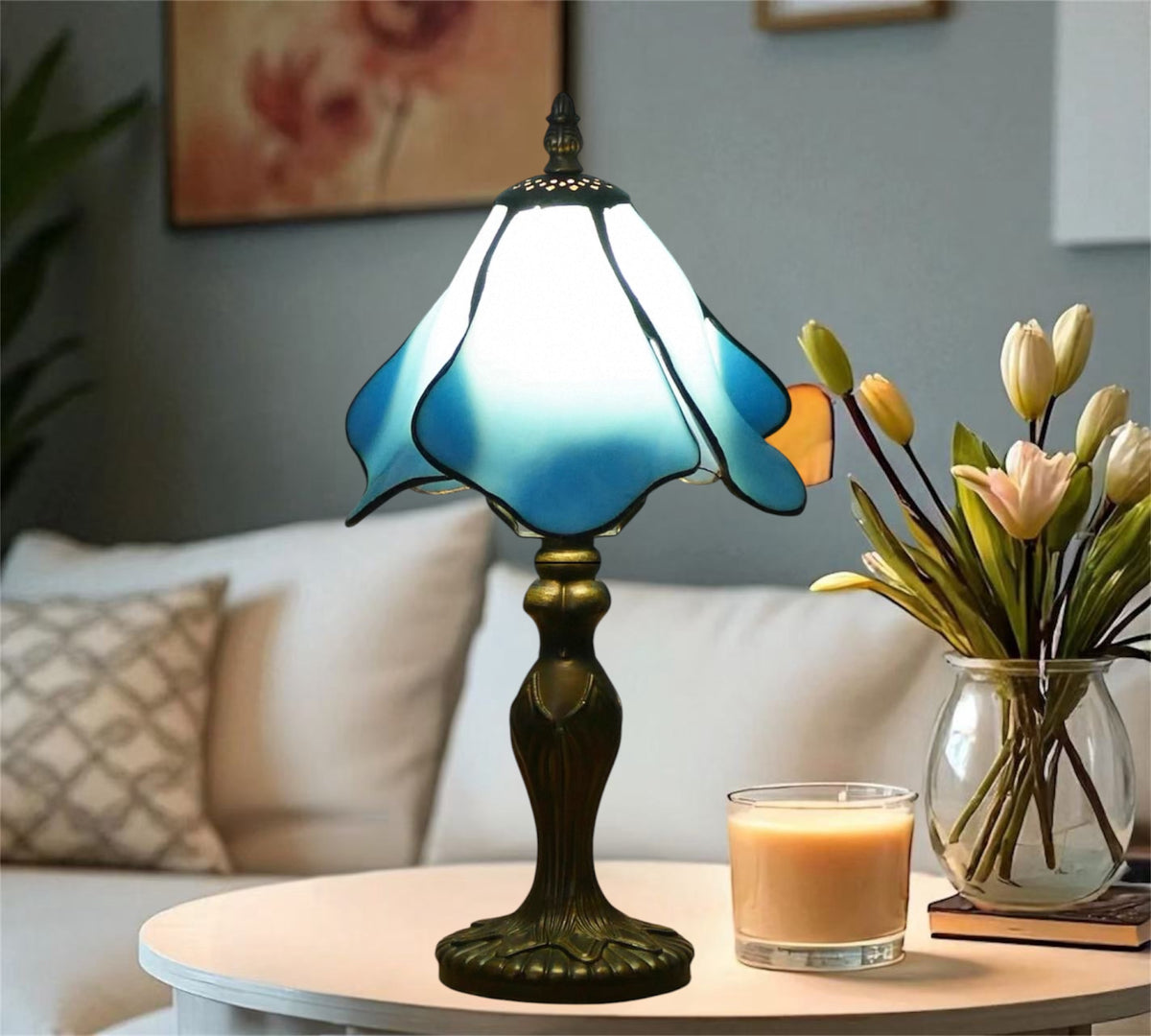 Stained glass table lamp with glowing blue shade and ornate bronze base