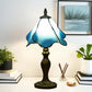 Blue and white stained glass table lamp with tall bronze pedestal base