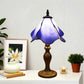 Table lamp with purple-blue stained glass shade and decorative gold metal base