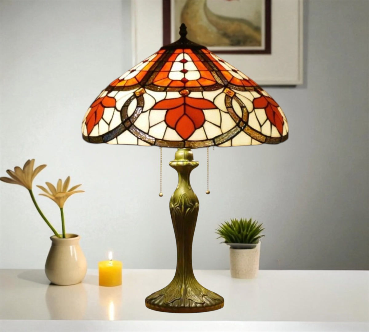 Tiffany table lamp with stained glass shade, bronze base with ornate foot, small candles nearby