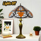Tiffany table lamp with stained glass shade and bronze base, lights off