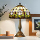 Tiffany-style stained glass table lamp with arched multicolor floral shade and bronze base
