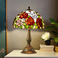Three-quarter view Tiffany-style stained glass table lamp with floral shade and bronze metal base